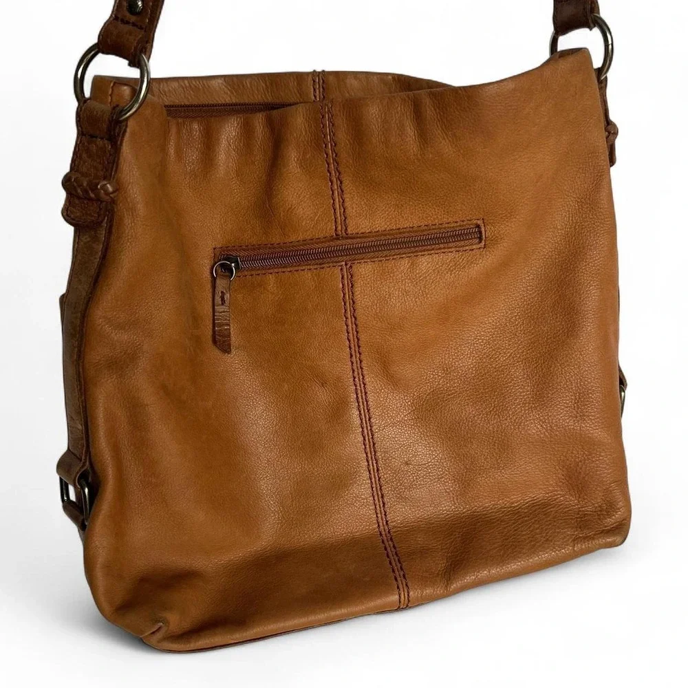 Tan leather shoulder bag with zipper closure, multiple pockets & braided tassel